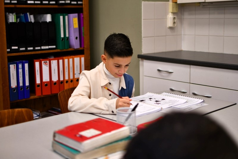 Docent begeleidt een leerling bij het rekenen